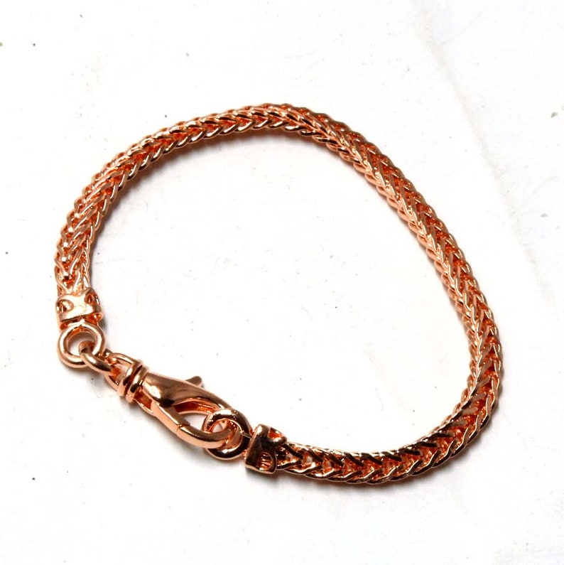 Peut inclure: Un bracelet en cha&icirc;ne or rose avec une fermeture &agrave; fermoir. La cha&icirc;ne est de conception tress&eacute;e.