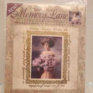 May include: A Memory Lane iron-on transfer package featuring a vintage image of a young girl holding flowers. The package includes text that reads "Violets, Violets, Violets the smell so sweet, and true, reminds me of our dear friendship." The actual transfer size is 8 1/2 x 11 1/4 inches.