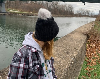 Black hat and gray pom pom