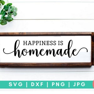 May include: A wooden sign with a white background and black text that reads "Happiness is homemade".