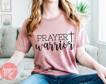 May include: A pink t-shirt with the text "PRAYER warrior" and a cross printed on it.