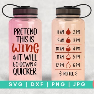 Op de afbeelding: Een roze waterfles met een zwarte dop en een zwarte band. De fles heeft een wit ontwerp met de tekst "Pretend This Is Wine It Will Go Down Quicker". De andere kant van de fles heeft een wit ontwerp met een waterdruppelpictogram en de tekst "8 AM 2 PM 9 AM 3 PM 10 AM 4 PM 11 AM 5 PM 12 PM 6 PM >REFILL<".