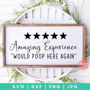 K&ouml;nnte beinhalten: Ein wei&szlig;es Holzschild mit braunem Rahmen, auf dem f&uuml;nf schwarze Sterne und der Text "Amazing Experience "Would Poop Here Again" zu sehen sind.