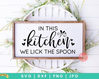 Könnte beinhalten: Ein weißes Holzschild mit dem Text "IN THIS kitchen WE LICK THE SPOON" in schwarzen Buchstaben. Das Schild liegt auf einem weißen Weidenkorb.
