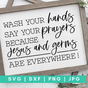 May include: A white sign with black text that reads "Wash your hands, say your prayers because Jesus and germs are everywhere!" The sign is framed in a light brown wood frame.