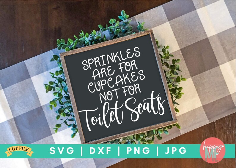 K&ouml;nnte beinhalten: Ein schwarzes Schild mit wei&szlig;em Text, auf dem steht "Sprinkles are for cupcakes not for toilet seats". Das Schild ist in Holz gerahmt und von gr&uuml;nem Laub umgeben.