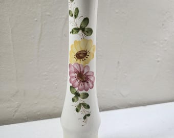May include: A tall, white ceramic vase with a yellow ombre base and hand-painted floral designs. The vase features yellow and pink flowers with green leaves and stems. The vase is approximately 10 inches tall.