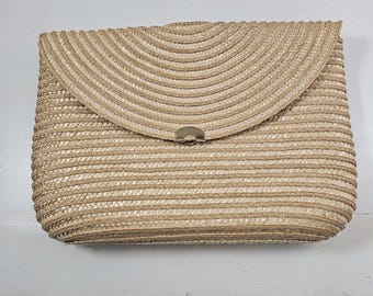 May include: A rectangular, woven straw clutch with a curved flap closure. The clutch is a light tan color with a metal clasp. The woven pattern is horizontal on the body and curved on the flap. A stylish accessory for any occasion.