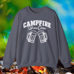 May include: A dark gray sweatshirt with the text "Campfire Brew Crew" in white lettering. The sweatshirt features two white beer mugs with foam on top.