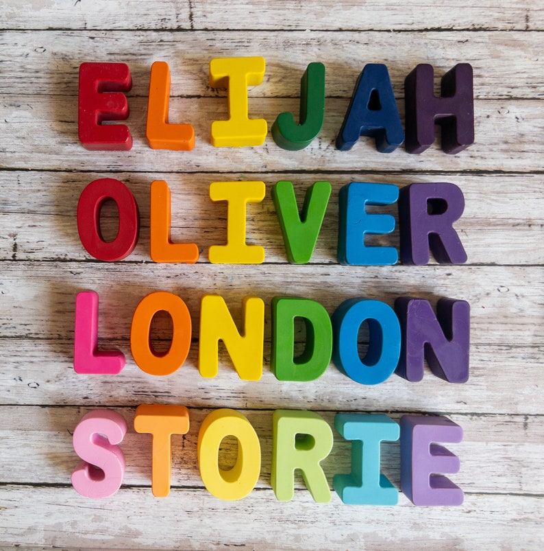 May include: Colorful wooden letter blocks spelling out the names Elijah, Oliver, London, and Storie on a white wood background.