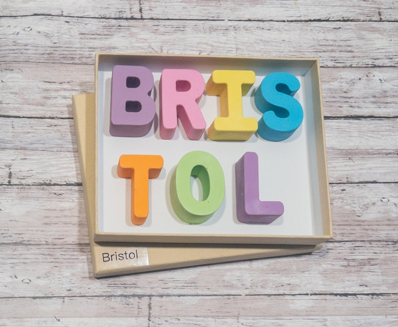 May include: A wooden box with the name "Bristol" spelled out in colorful letters. The letters are in a variety of colors, including pink, purple, yellow, orange, green, and blue.