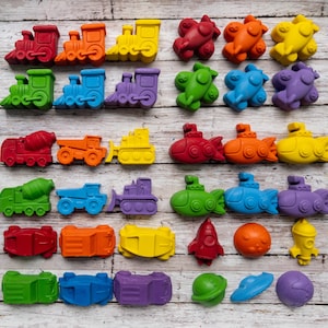 May include: A collection of colorful toy vehicles and space-themed objects. The toys include trains, construction vehicles, submarines, cars, a rocket, a planet, a UFO, and a space station. The toys are in various colors, including red, orange, yellow, green, blue, and purple.