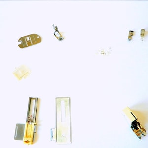 Puede incluir: Surtido de pies y accesorios para máquina de coser, que incluyen un pie para zigzag, un pie para ojal, un pie para cremallera, un pie para puntada invisible, un pie para caminar, un pie para zurcir, un pie para movimiento libre, un pie para acolchar, un descosedor y un enhebrador de agujas.