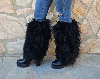 May include: Black faux fur boot cuffs with a thick, fluffy texture. The cuffs are worn over black heeled boots with a platform sole.