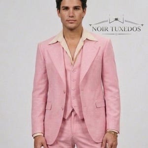 Puede incluir: Un traje de tres piezas rosa claro con chaqueta, chaleco y pantalón a juego. El traje se lleva sobre una camisa de cuello beige claro. El texto "NOIR TUXEDOS" se muestra en la imagen.