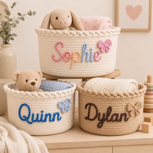 May include: Three round woven storage baskets in cream and tan colours. Each basket features a braided rim and a personalised name in raised yarn lettering: Sophie in pink and blue, Quinn in blue, and Dylan in brown, with small yarn butterflies.