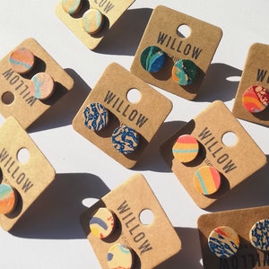 May include: Assortment of colourful, patterned cork earrings on brown card stock with the word "WILLOW" printed on each card.