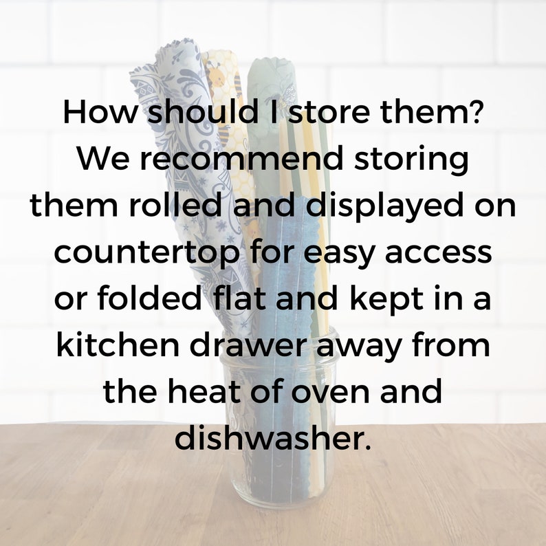 May include: A close-up of a glass jar filled with colorful fabric squares. The text reads: "How should I store them? We recommend storing them rolled and displayed on countertop for easy access or folded flat and kept in a kitchen drawer away from the heat of oven and dishwasher."