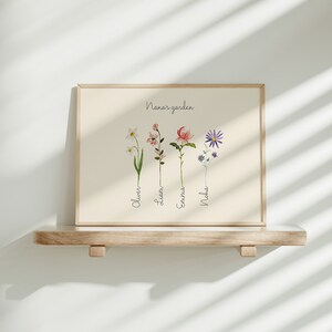 May include: A framed print with the text "Nana's garden" and four illustrated flowers with names below them: Oliver, Liam, Emma, Noah.