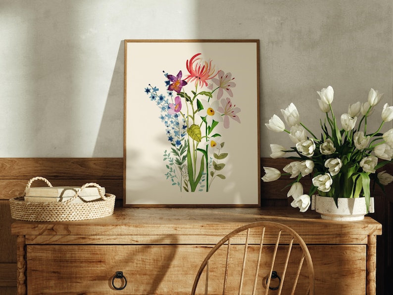 May include: A framed print of a watercolour painting featuring a bouquet of flowers in shades of pink, purple, blue, green, and yellow. The flowers include orchids, daffodils, and other blooms.