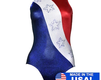 Op de afbeelding: Een blauwe, witte en rode turnpak met een diagonaal ontwerp en strass steentjes in de vorm van sterren. Het turnpak heeft een ronde hals en een racerback-stijl. De tekst "MADE IN THE USA!" is afgedrukt in de rechterbenedenhoek van de afbeelding.