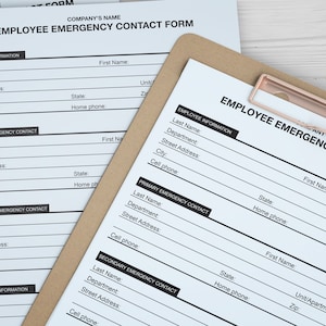 Pu&ograve; includere: Un modulo bianco di carta con il titolo "Modulo di contatto di emergenza per i dipendenti" su una clipboard marrone. Il modulo contiene campi per le informazioni sui dipendenti, il contatto di emergenza principale e il contatto di emergenza secondario.