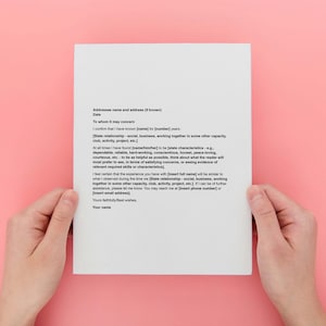 May include: A white sheet of paper with black text is held by two hands against a pink background. The text is a formal letter with placeholders for information. The paper is centered in the frame.