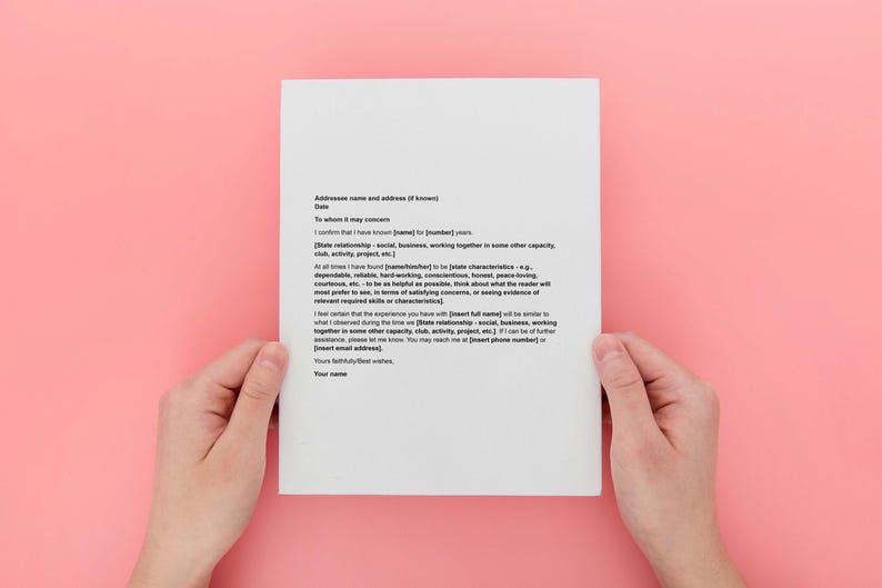 May include: A white sheet of paper with black text is held by two hands against a pink background. The text is a formal letter with placeholders for information. The paper is centered in the frame.