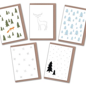 May include: A collection of five greeting cards with nature-themed illustrations. Designs include a fox in a forest, a deer, blue trees, snowflakes, and black trees. Each card has a white interior and a brown border.