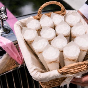 white cones filled with white confetti. confetti bags and confetti envelopes