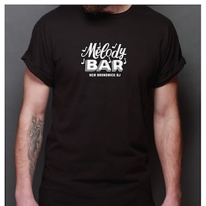 May include: A black t-shirt with a white graphic that says "Melody Bar" with musical notes and "New Brunswick NJ".