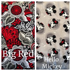 May include: Two fabric swatches, one with a black background and a red, white, and gray floral pattern, and the other with a gray background and a repeating pattern of Mickey Mouse in a circle. The text "Big Red" is visible on the floral swatch and "Hello Mickey" is visible on the Mickey Mouse swatch.