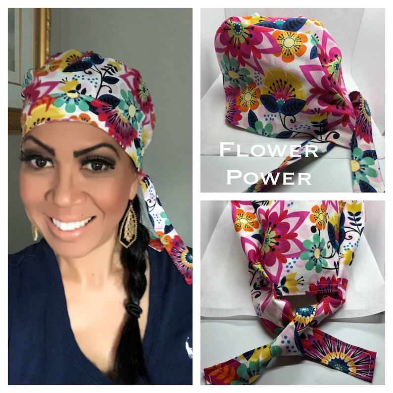 May include: A white surgical cap with a colorful floral print. The cap has a long tie that can be tied at the back of the neck. The cap is called "Flower Power".