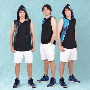 Könnte beinhalten: Drei Personen tragen schwarze ärmellose Kapuzenpullover mit Batik-Akzenten und weiße Shorts. Jede Person trägt schwarz-blaue High-Top-Sneaker. Der Hintergrund ist hellblau.