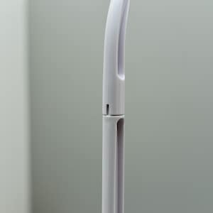 May include: A white plastic handle with a curved top and a small hole in the middle. The handle is designed to be used with a cleaning tool.