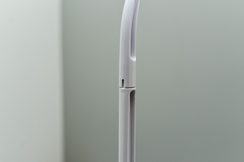 May include: A white plastic handle with a curved top and a small hole in the middle. The handle is designed to be used with a cleaning tool.