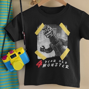 May include: Black t-shirt with a graphic of a monster and the text "4 year old monster".