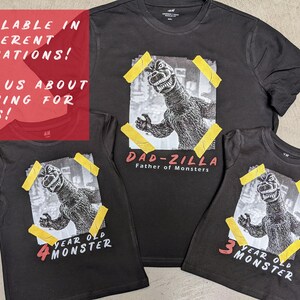 May include: Three black t-shirts with a graphic print of Godzilla. The largest shirt says "Dad-zilla Father of Monsters". The other two shirts say "4 year old monster" and "3 year old monster".