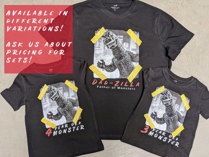May include: Three black t-shirts with a graphic print of Godzilla. The largest shirt says "Dad-zilla Father of Monsters". The other two shirts say "4 year old monster" and "3 year old monster".