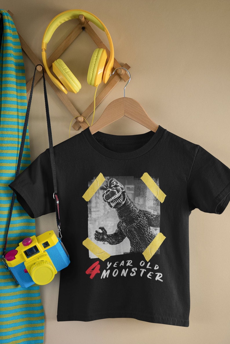 May include: Black t-shirt with a graphic of a monster and the text "4 year old monster".