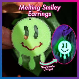 Könnte beinhalten: Grüne, schmelzende Smiley-Ohrringe. Die Ohrringe haben ein tropfendes Design mit rotem Mund und schwarzen Augen. Der Text "Melting Smiley Earrings" steht darüber. Sie leuchten unter UV-Licht.