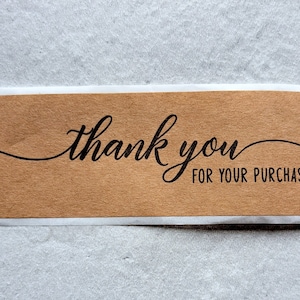 May include: A brown paper thank you sticker with the text "thank you for your purchase" in black cursive font.