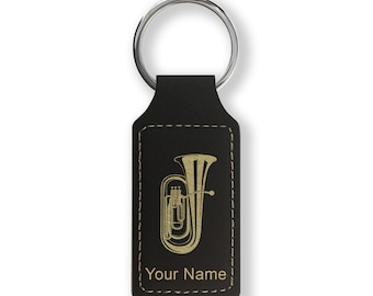 May include: Black leather keychain with a gold-colored tuba design and the text "Your Name".