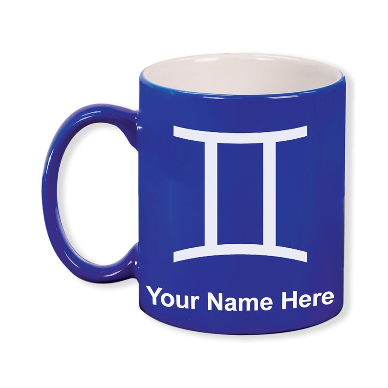 May include: A cobalt blue ceramic mug with a white interior and handle. The mug features a white Gemini zodiac symbol and the text "Your Name Here" in white. The mug is designed for personalization.