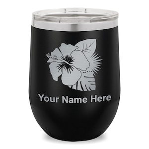 May include: Black insulated tumbler with a silver floral design, including a hibiscus flower and leaves. The text "Your Name Here" is printed below the design. The tumbler has a silver rim and a clear lid.