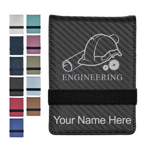 May include: A black carbon fiber wallet with a black elastic strap, featuring an engraved graphic of a hard hat, a rolled blueprint, and two gears above the text ENGINEERING and the placeholder text Your Name Here, with color variations shown.