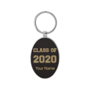 May include: Black oval keychain with a silver metal ring. The keychain has gold text that reads "Class of 2020" and "Your Name".
