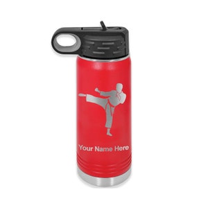 May include: Red stainless steel water bottle with a black lid and a carrying handle. The bottle has a silver silhouette of a person doing a karate kick and the text "Your Name Here" engraved on the side.
