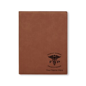 May include: Brown leather journal with a black engraved design of a caduceus, the text "Family Nurse Practitioner FNP" and the words "Your Name Here".