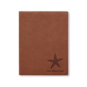 May include: Brown leather journal with a starfish design and the text "Your Name Here" engraved on the front.